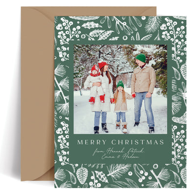 Custom Christmas card with family photo and green and white winter foliage design