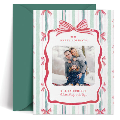 Custom holiday card with a family photo and festive design, featuring a red bow and striped border.