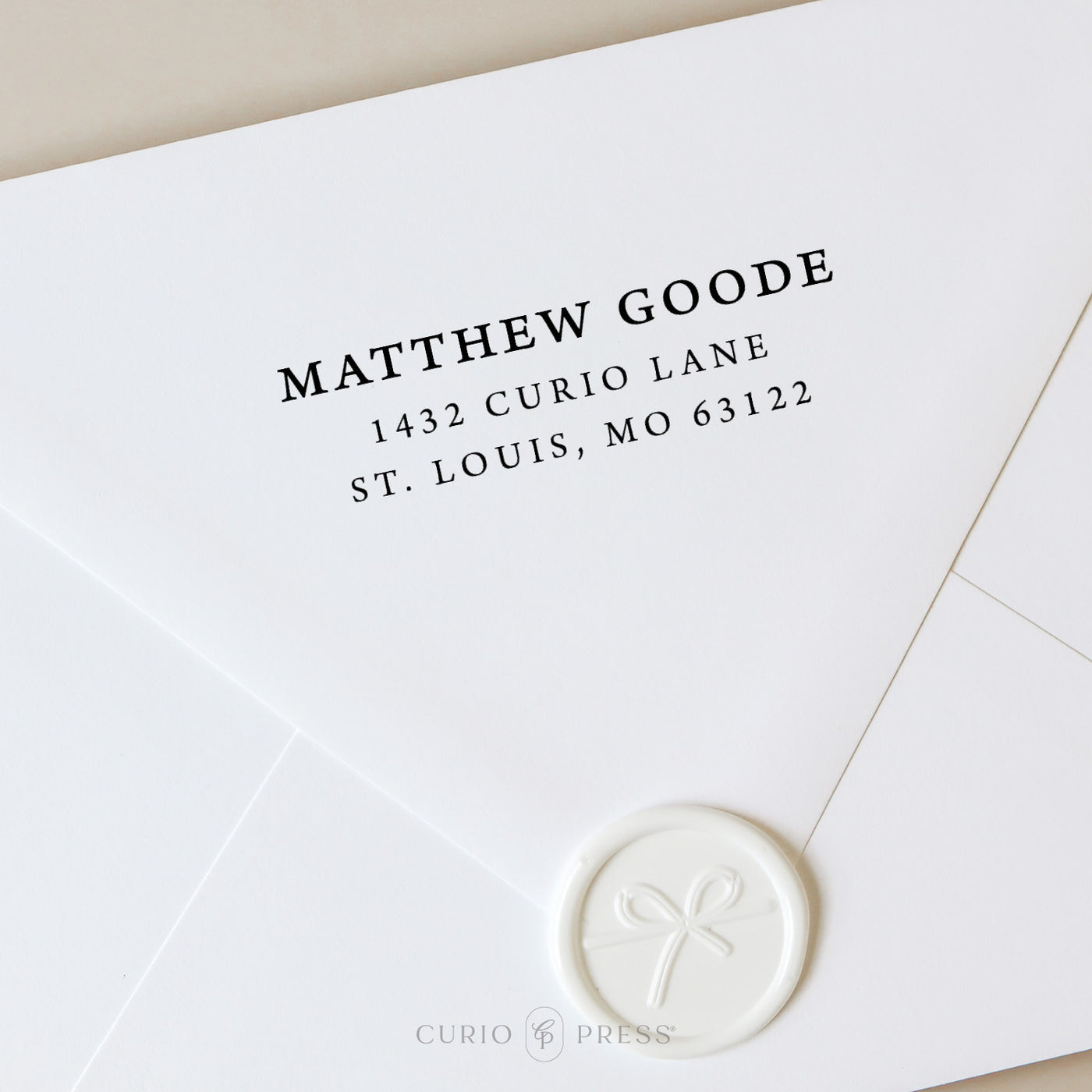 Elegant address stamp with full serif font for name and address, stamped in black ink on envelope for a traditional look