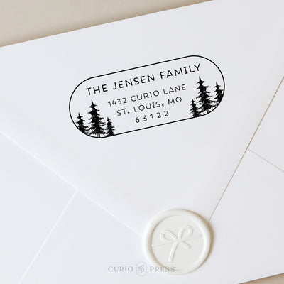 Oval address stamp design with hand-drawn trees on either side and modern rounded text centered inside the frame