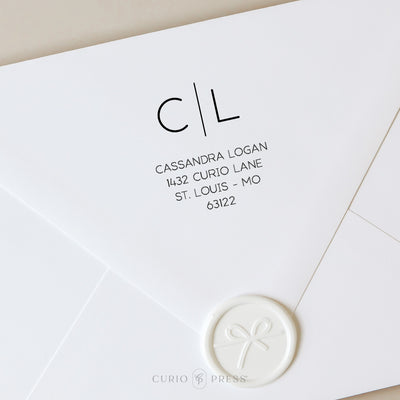 Modern custom address stamp with two-letter monogram above a dividing line and clean printed name and address below