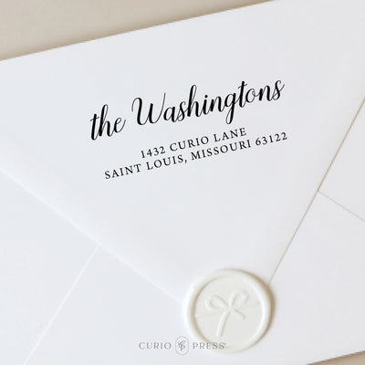 Custom address stamp with script last name and printed mailing address, stamped in black ink on a white envelope with wax seal