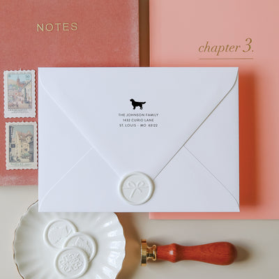 Custom Retriever address stamp on a white envelope with wax seal with a wood handled embosser