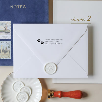 Adorable paw print address stamp on a white envelope with wax seal on a neutral background with vintage stamps