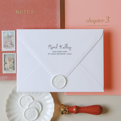 White envelope with elegant personalized address on a styled background with a vintage wax seal stamp